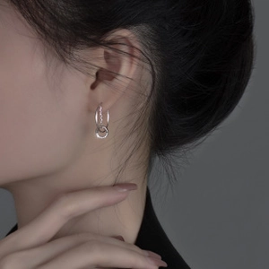 Close-up of minimalist 925 sterling silver interlocking hoop earrings on a model