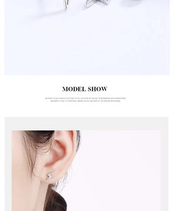 Detail view of silver lightning bolt stud earrings with crystals on a female ear model