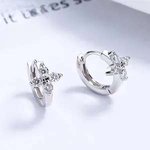 Vue macro de boucles d'oreilles fleurs en argent avec zircons clairs et fini poli