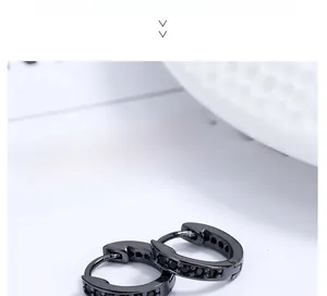Vue macro de boucles d'oreilles créoles noires serties de zircons sur fond de papier