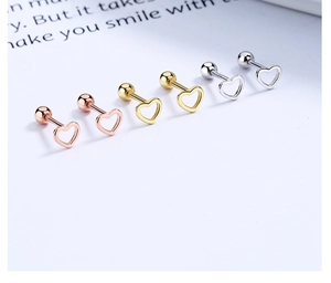 Vista macro di orecchini a cuore in argento 925 color oro, oro rosa e argento