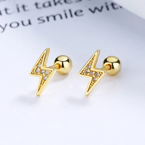 Macro shot of gold lightning bolt earrings with micro-inlaid zircons and screw backs