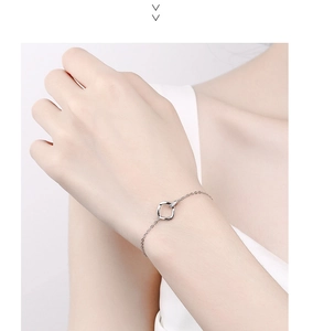 Close-up of silver Mobius bracelet featuring a square pendant with small zircons
