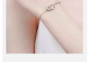 Close-up of a minimalist 925 sterling silver interlocking double ring bracelet on wrist