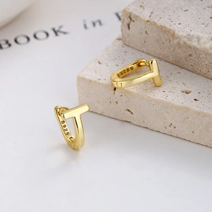 Minimalist T-shape 925 sterling silver hoop earrings in gold finish on stone display