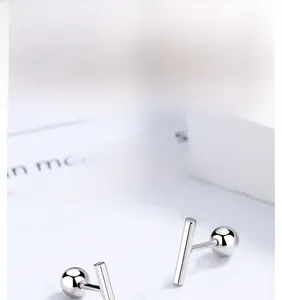 Macro shot of 925 silver T-shaped stud earrings featuring a polished bar design