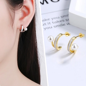 Close-up detail of leaf-shaped pearl earrings with mother-of-pearl shell inlay