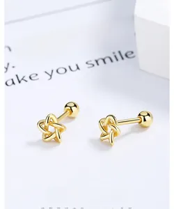 Detailed macro view of gold-plated star stud earrings with secure screw-back ball closures