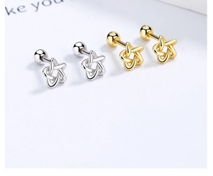Macro detail of 925 sterling silver star stud earrings with screw back in gold and silver