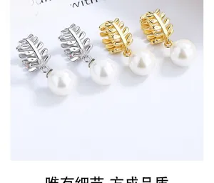 Detailed view of silver and 18K gold leaf pearl earrings with high-quality finish