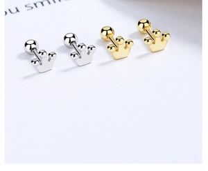 Detailed close-up of crown screw back earrings in gold and silver finishes on white card