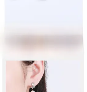 Close-up of elegant leaf design silver earrings with white pearl pendants