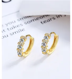 Macro view of gold hoop earrings with sparkling cubic zirconia stones and polished finish