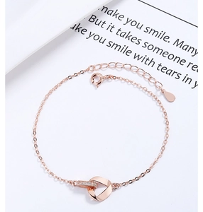 Detail of rose gold Mobius bracelet with interlocking rings and sparkling zircon stones