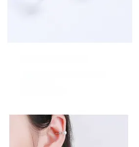 Detail of elegant pearl and zircon ear cuff on ear without piercing in silver finish