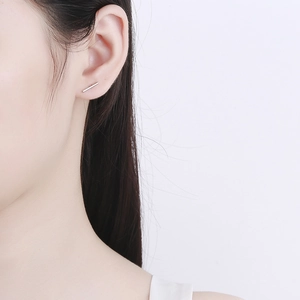 Minimalist 925 sterling silver bar stud earring shown on a model for daily wear