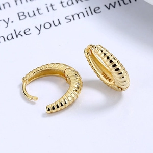 Detailed close-up of gold croissant hoop earrings with S925 hallmark and ribbed texture