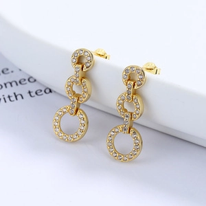 Close-up of golden triple-hoop drop earrings pavé-set with shimmering cubic zirconia