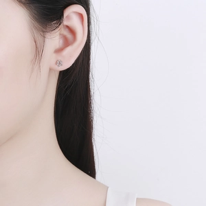 Minimalist 925 sterling silver star stud earring on female model with metallic luster