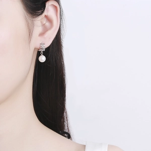 Silver leaf earrings with white round pearls shown on a model for elegant look
