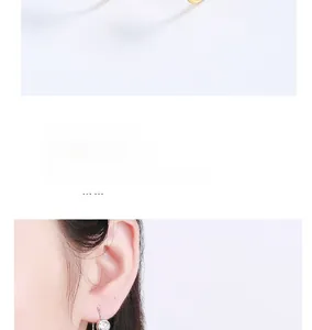Detailed view of silver hook earrings with bezel-set round brilliant-cut clear zircon stones