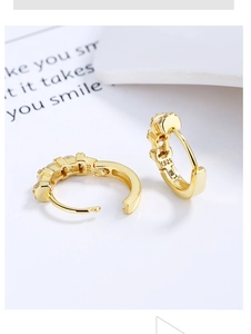 Macro detail of gold S925 sterling silver hoop earrings with pavé cubic zirconia