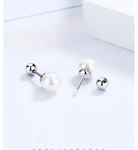 Détail de boucles d'oreilles perles en argent à fermoir à vis sur carte décorative