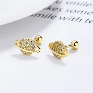 Detailed close-up of golden clover saturn stud earrings with sparkling white zircons