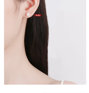 Gros plan détaillé montrant une boucle d'oreille perle 6mm portée sur le lobe