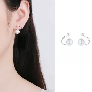 Dettaglio orecchini a perla in argento a forma di S con perle bianche a conchiglia