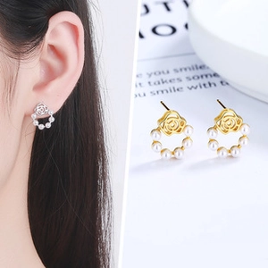 Detail view of 925 silver camellia earrings with small pearls in gold and silver finish