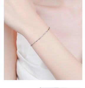 Macro view of minimalist 925 sterling silver square bar chain bracelet on wrist