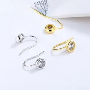 Macro shot of minimalist S925 sterling silver J-shaped earrings with round zircon stones
