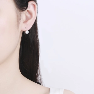 Minimalist 925 sterling silver hook earrings with round cubic zirconia on a female model