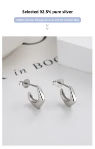 Close-up of S925 hallmark on minimalist silver U-shaped earrings for sensitive skin