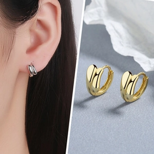 Detail of minimalist gold and silver double-layered round hoop earrings on a model
