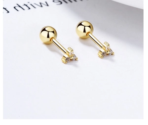 Detail of gold screw back earrings with three clear zircons in a triangle cluster