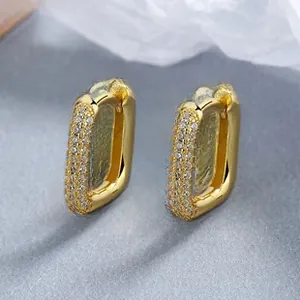 Detail view of U-shaped gold earrings with triple rows of pavé-set white cubic zirconia