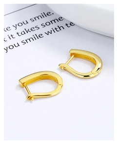 Macro shot of gold U-shaped S925 sterling silver earrings with clear hallmark engraving