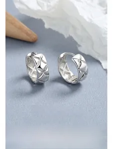 Gros plan de boucles d'oreilles en argent 925 avec un motif de losanges matelassés