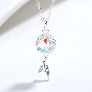 Macro shot of silver-tone necklace with iridescent gemstone and fish tail pendant
