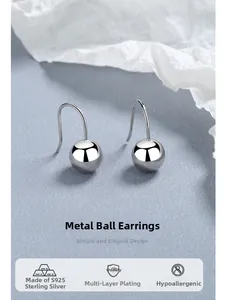 Macro detail of high-polish S925 sterling silver ball earrings with hypo-allergenic hooks