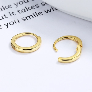 Eleganti orecchini a cerchio in argento 925 dorato con pietre di zirconia su sfondo bianco