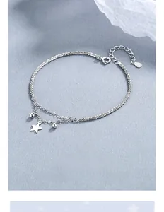 Detail of a double-layered 925 silver star bracelet with shimmering chain and beads