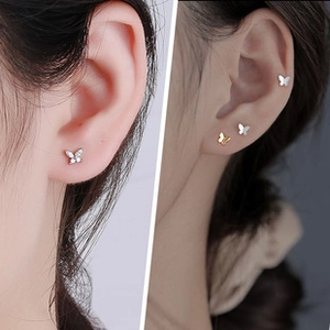 Detailed view of sterling silver butterfly stud earrings with zircon inlay on model