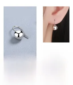 Detailed view of 925 sterling silver ball drop earrings with model wearing scene