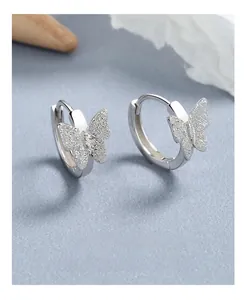 Macro view of silver butterfly hoop earrings with frosted wing textures and polished finish