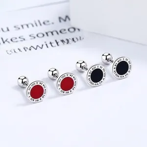 Detail of 925 silver stud earrings with Roman numerals and red or black inlay accents