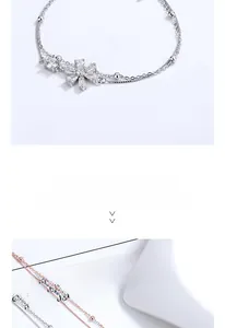 Detail of silver double-layered cherry blossom bracelet with flower-shaped gemstone charm