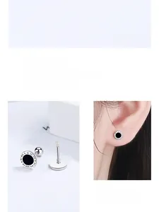 Detailed view of 925 silver screw earrings with Roman numerals and black circular design
